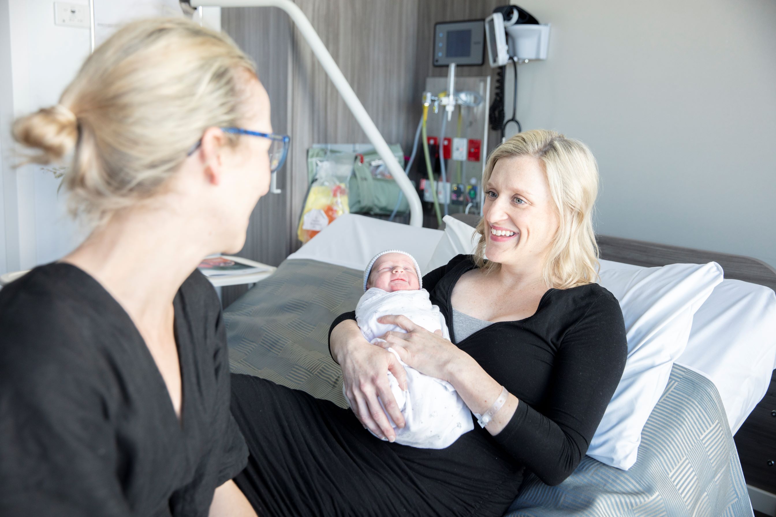 Patient holding newborn baby in hospital room with specialist.jpg