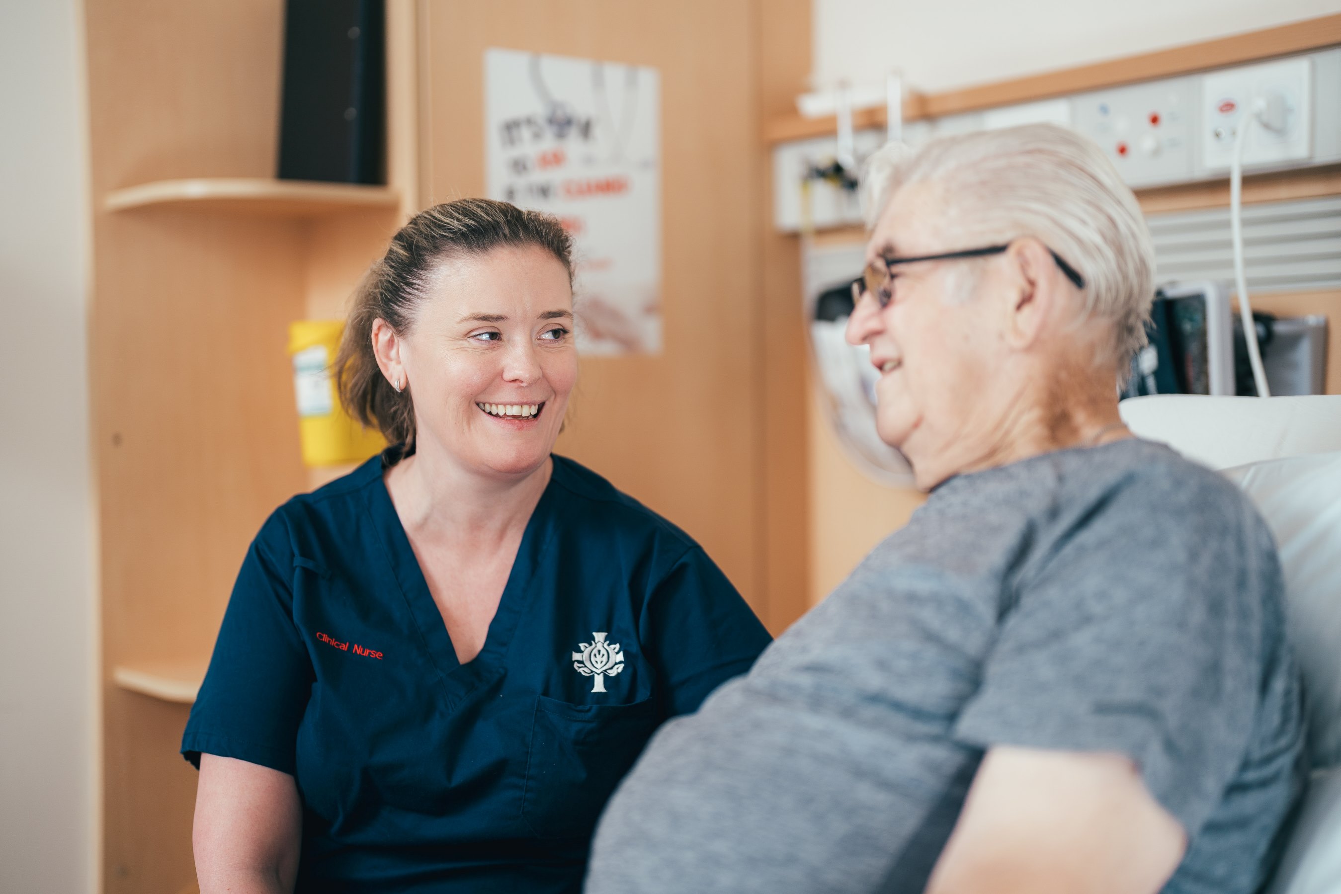 care giver peaking with elderly patient 