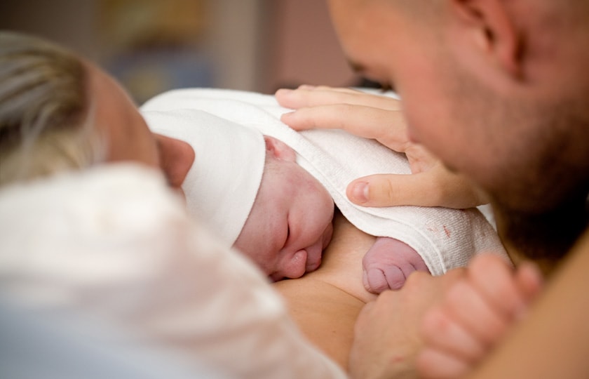 A father and mother with their newborn baby.