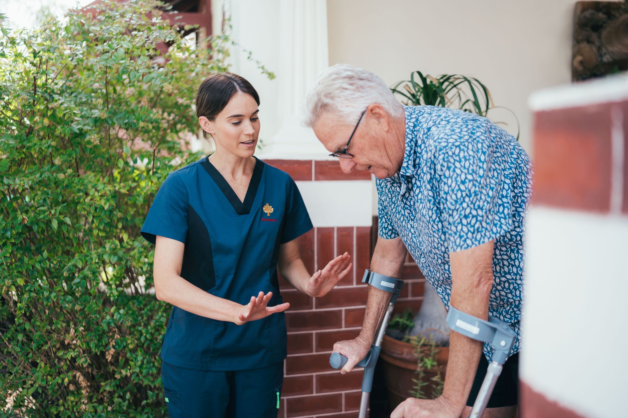 Caregiver assisting patient with walking up and down stairs