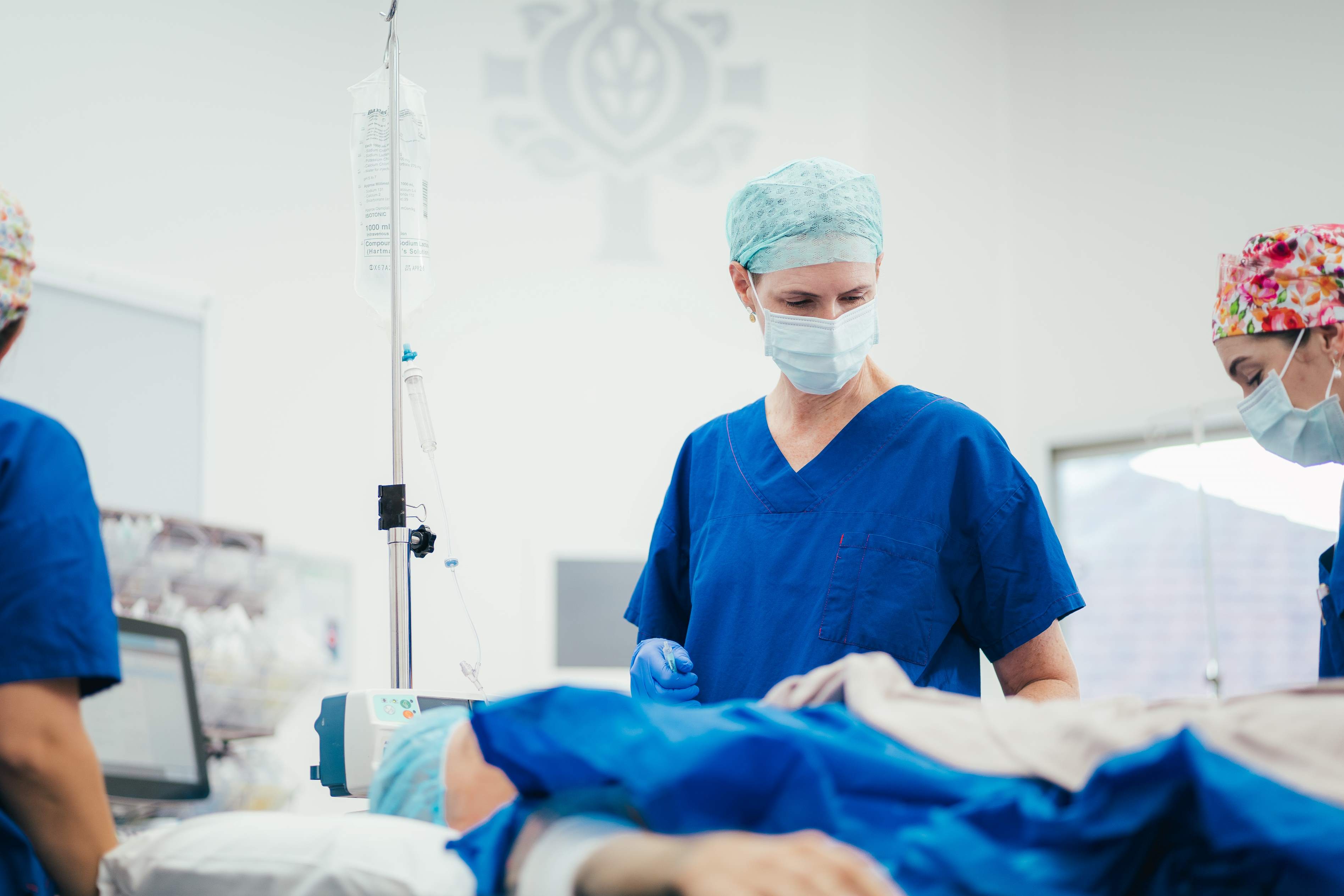 Caregivers and specialists in operating theatre preparing for surgery