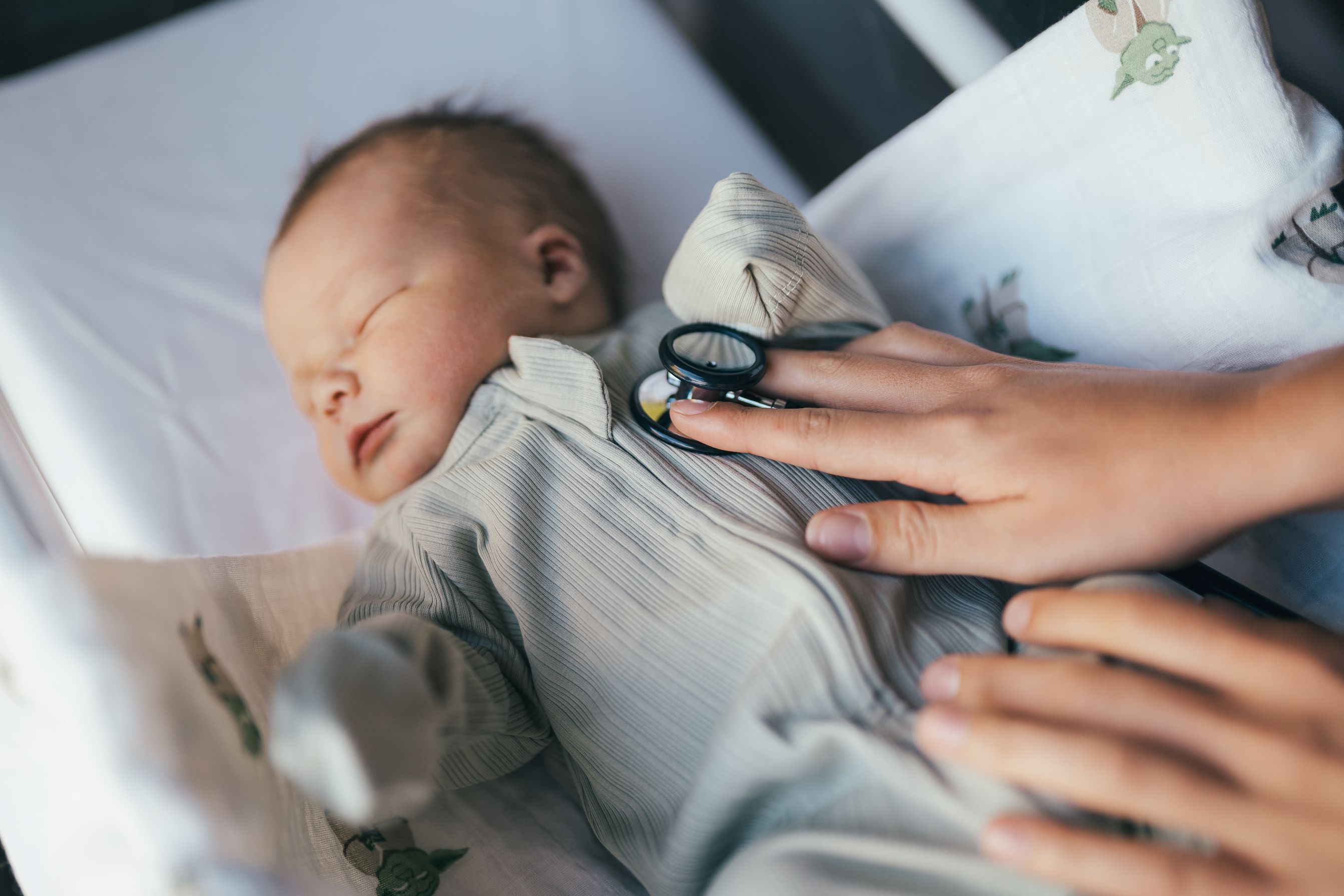 Doctor listening to heartbeat of newborn baby