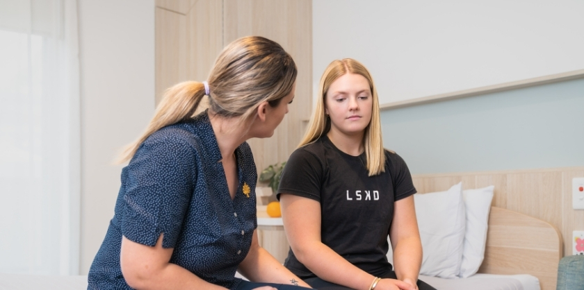 Healthcare professional consolidating a young woman while holding her hand around her