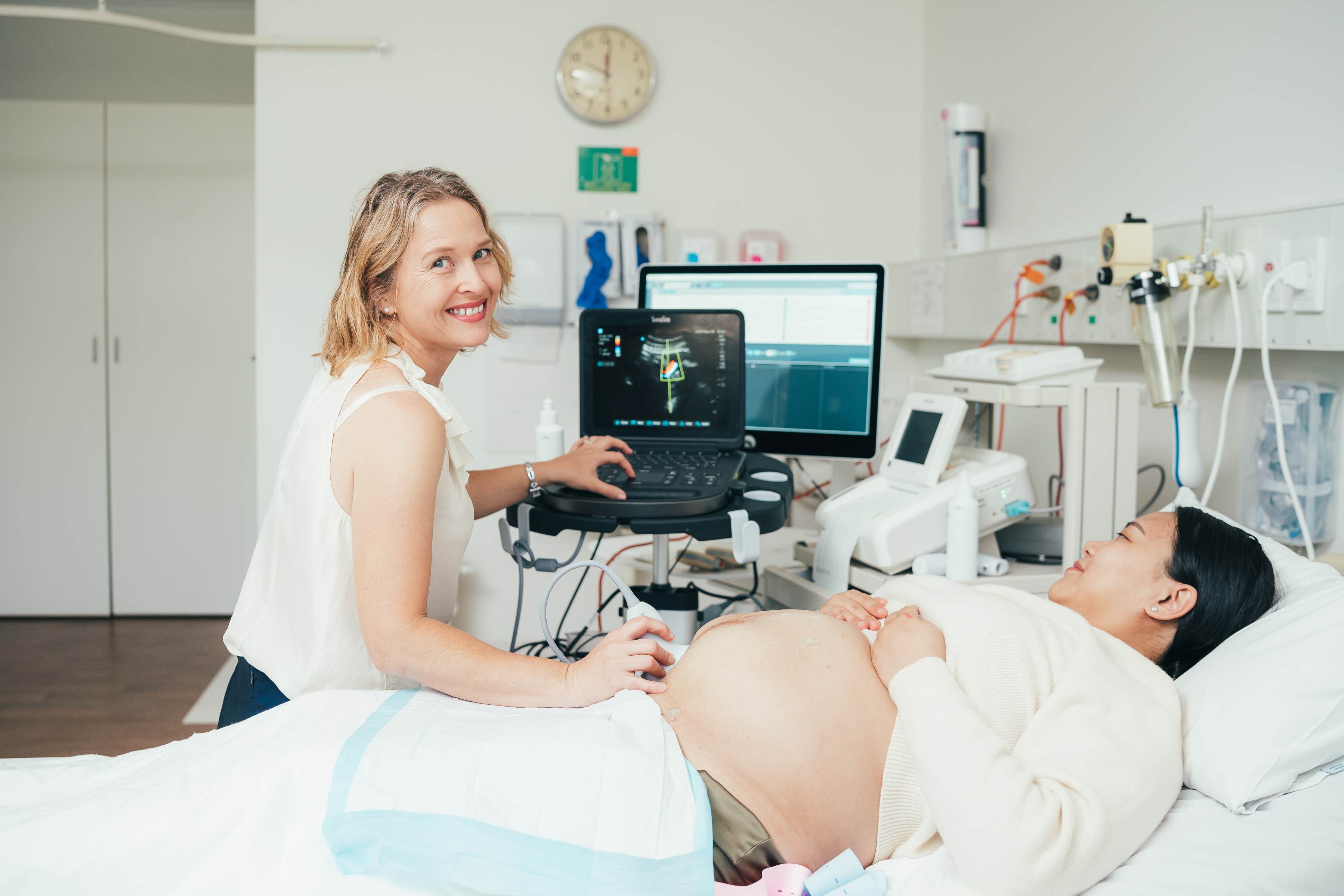 Obstetric specialist using equipment to perform ultrasound on pregnant patient