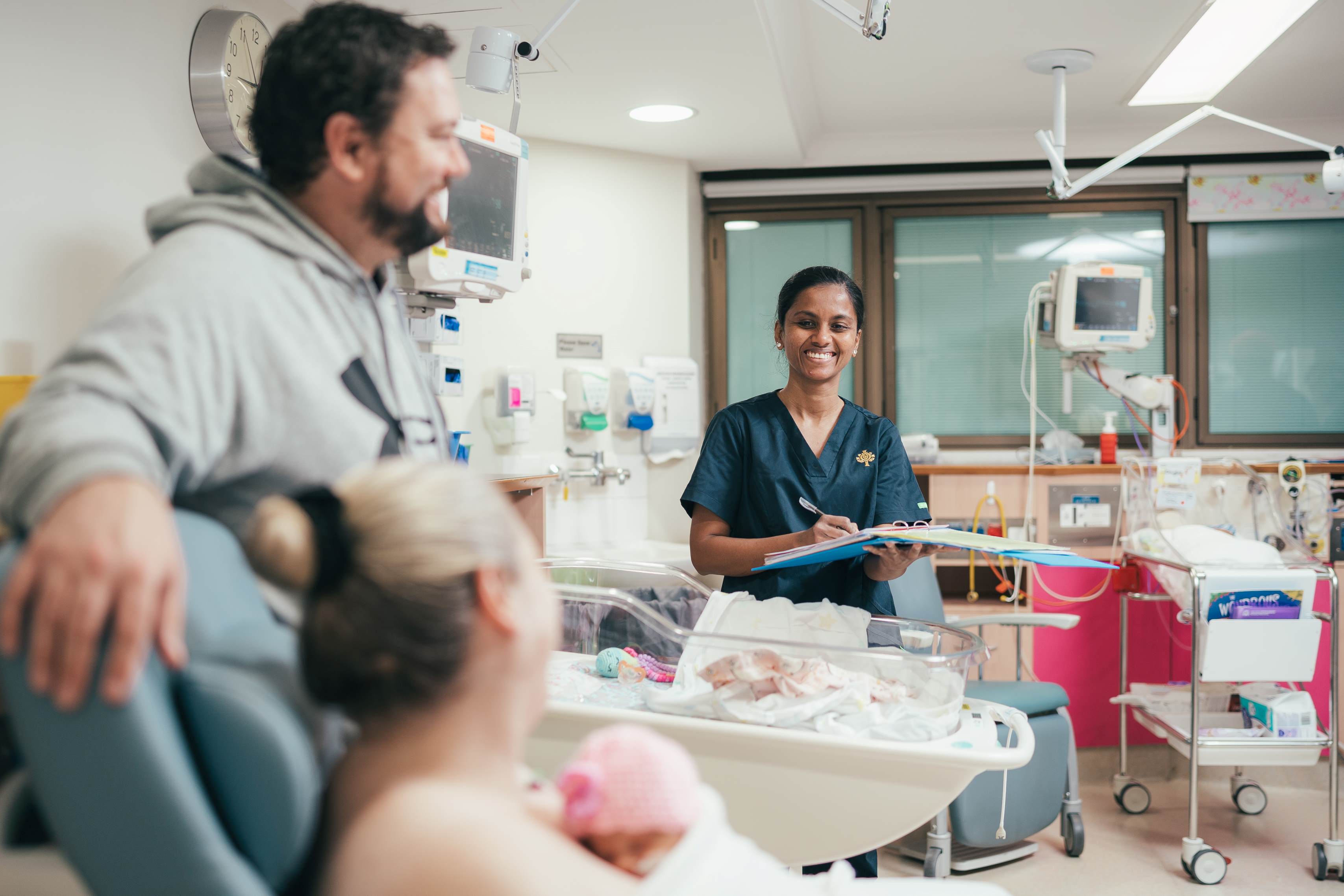 Caregiver with parents and newborn baby after birth