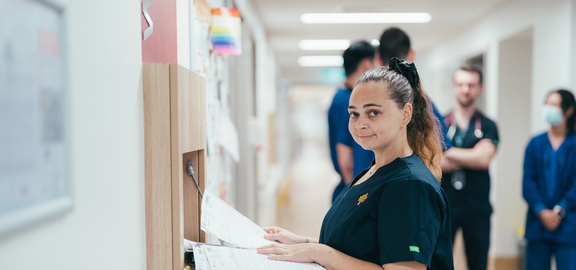 Caregiver greeting patient with a smile at the hospital admissions desk