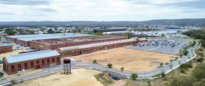 An empty block of land with buildings on one side and a road around the other, where the new St John of God Midland Private Hospital will be.