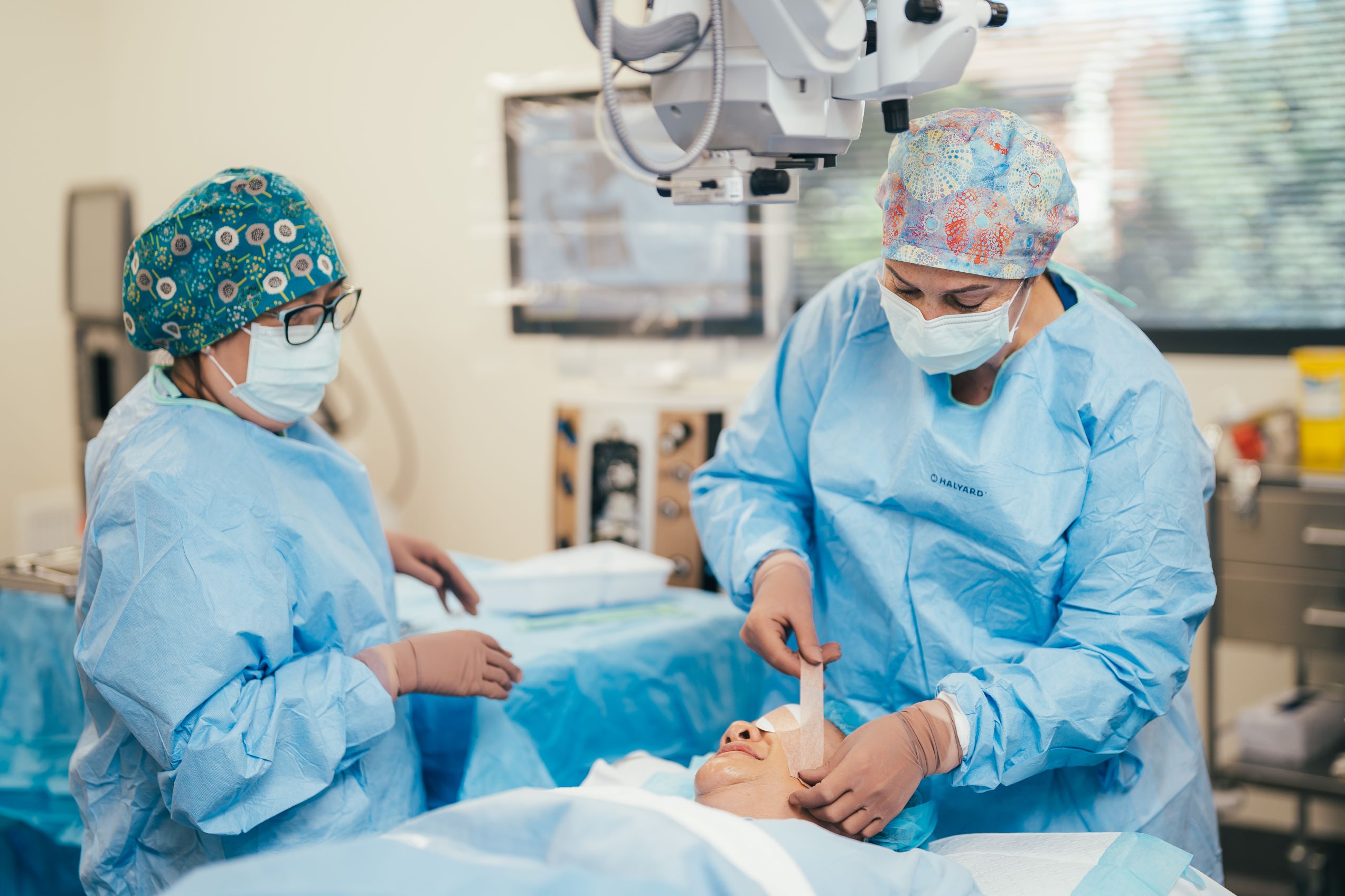Two caregivers with masks and gloves in operating theatre