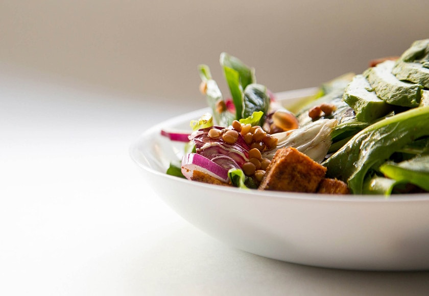 Bowl of salad with lentils, lettuce, red onion and avocado