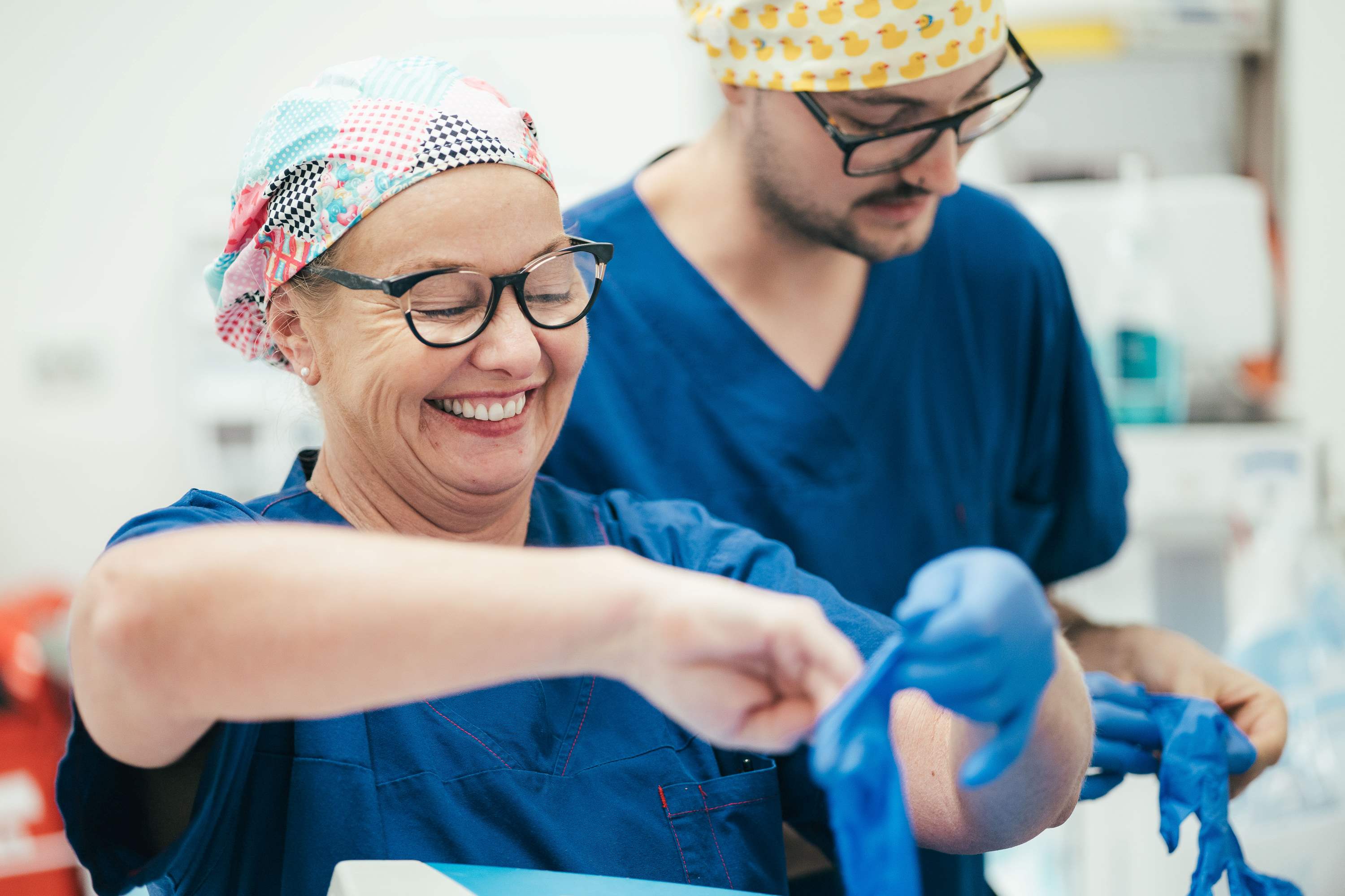 Two caregivers putting on gloves