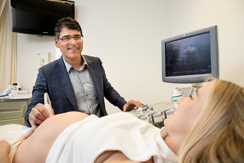 Dr Adam Gubbay using ultrasound on pregnant woman