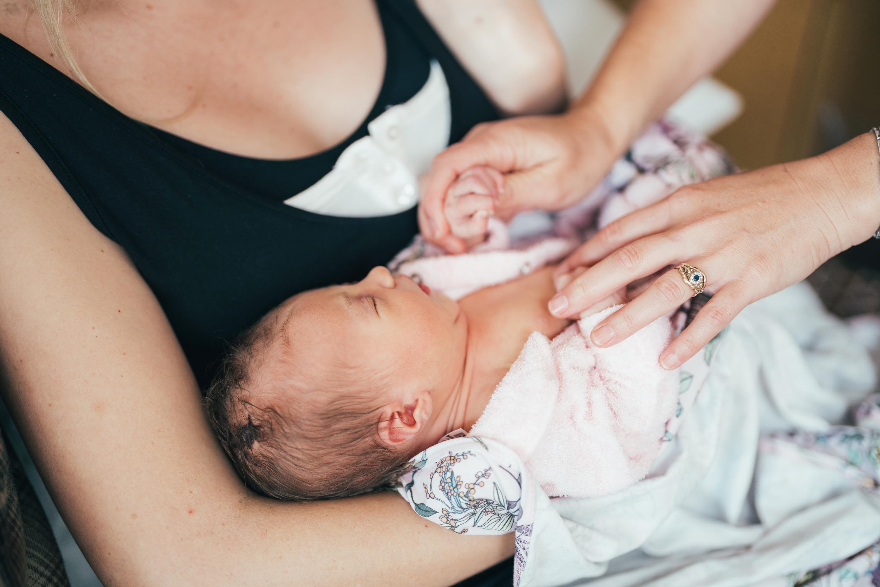 Mother holding newborn baby to her chest
