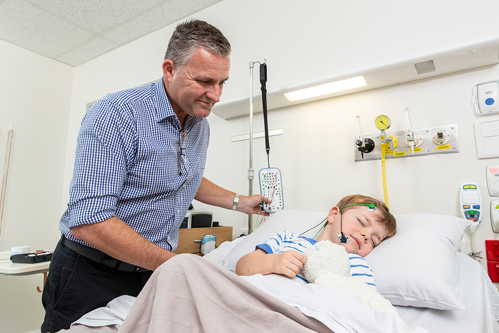 A sleep physician getting a paediatric patient prepared for a sleep study