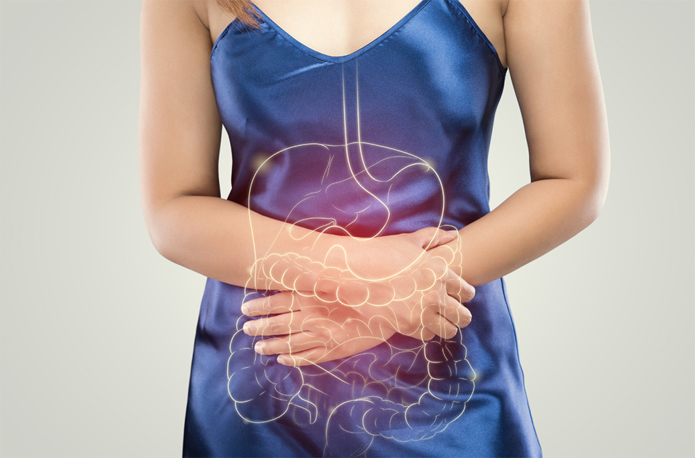 An illustration of a digestive tract overlaid on top of a person holding their stomach