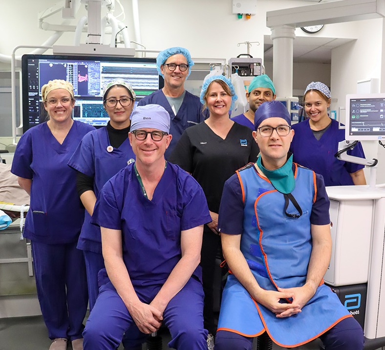 Group of caregivers dressed in scrubs posing for a photo
