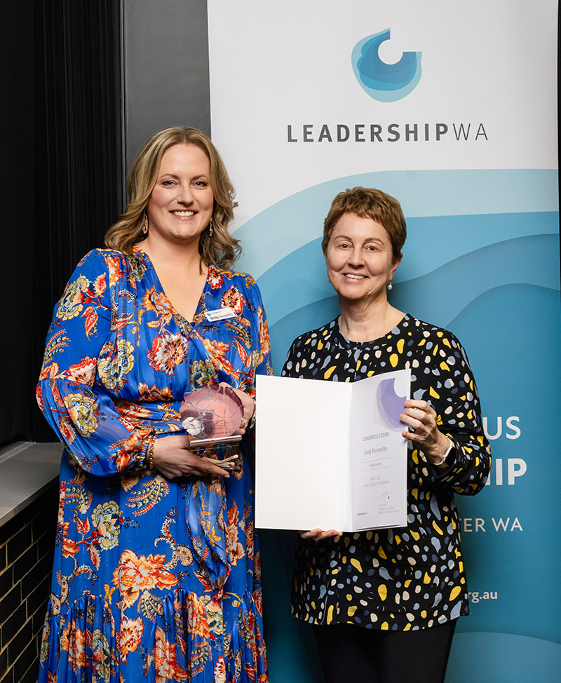 Emily Kenworthy smiles while holding award