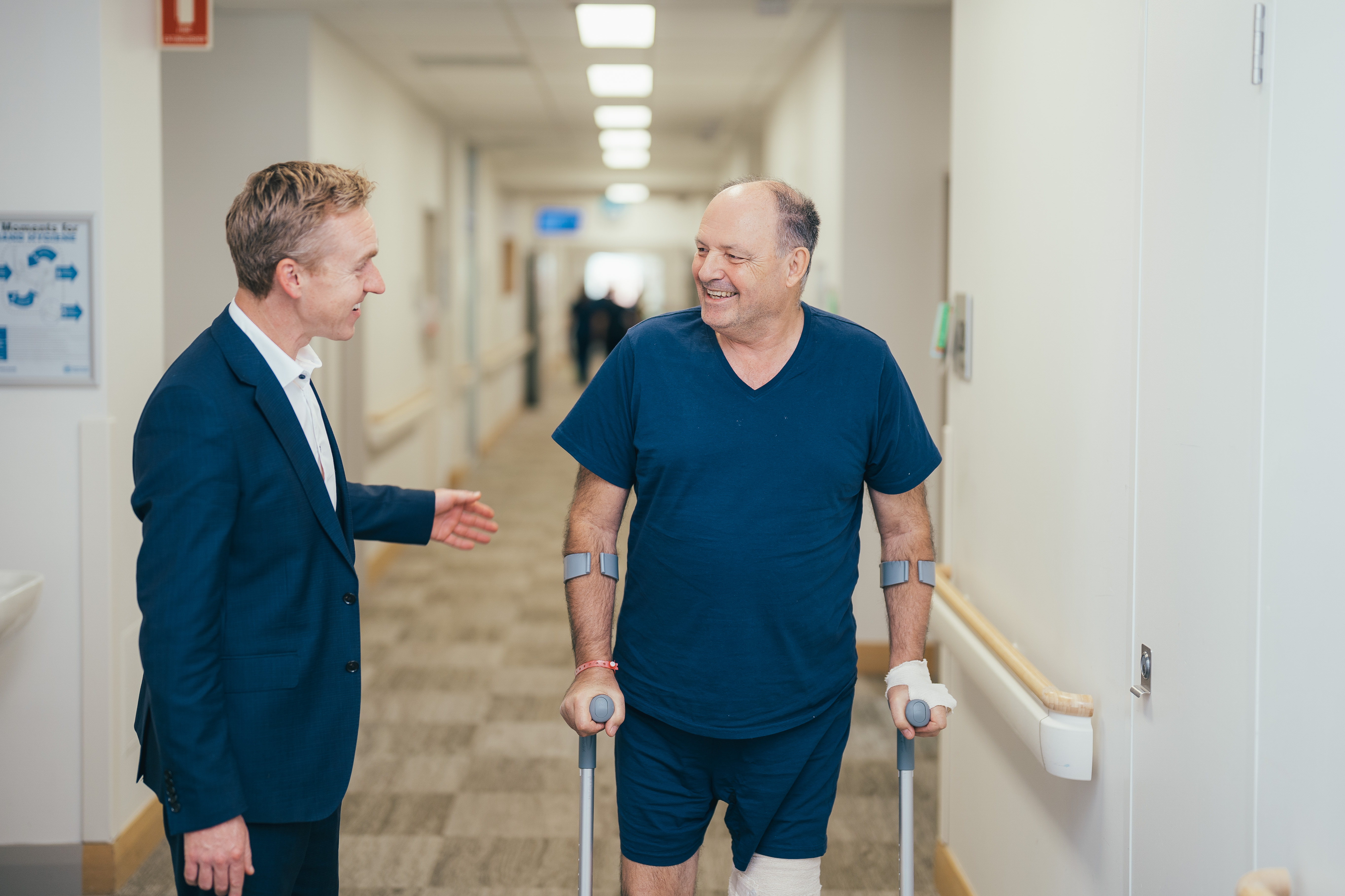 A doctor with a patient on stilts in a hallway