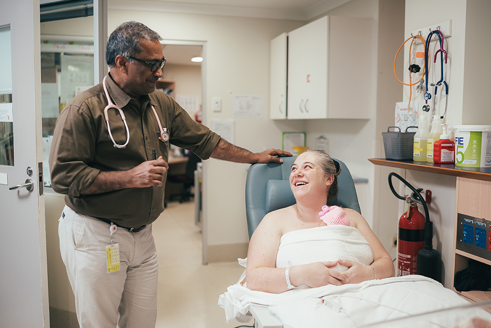 A maternity patient talks to her obstetrician after giving birth