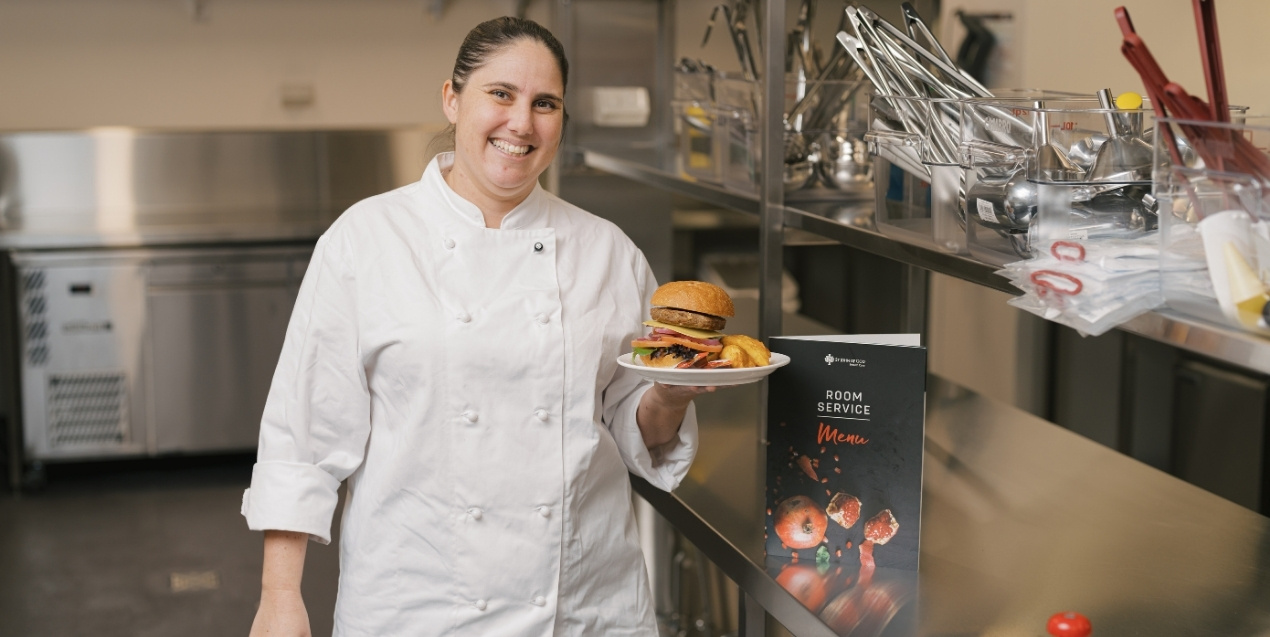 Chef holding up a plate of burger and fries
